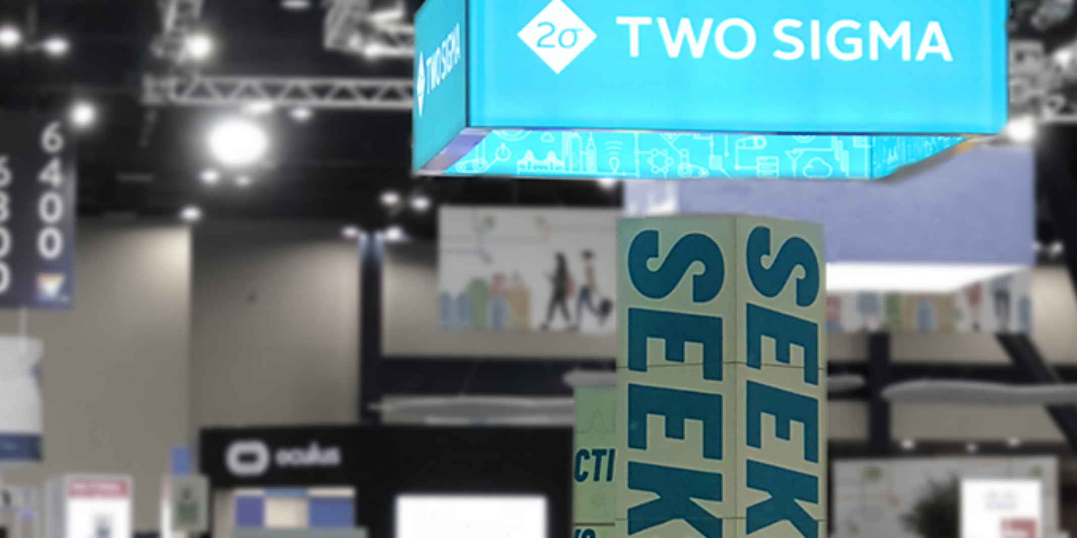 A blue Two Sigma sign hangs above a trade show floor near pillars reading 'SEEK.'