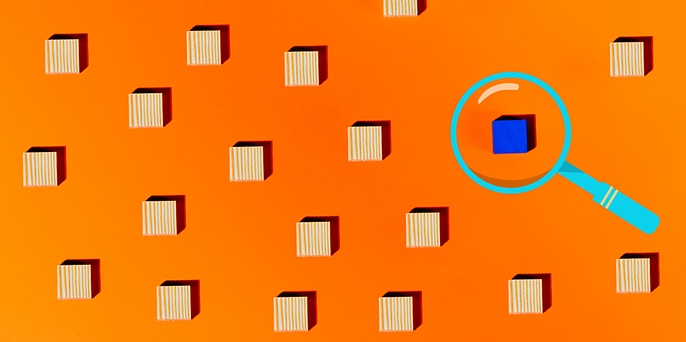 Rows of striped wooden cubes on an orange background, with one cube turned blue and highlighted inside a cyan magnifying glass.