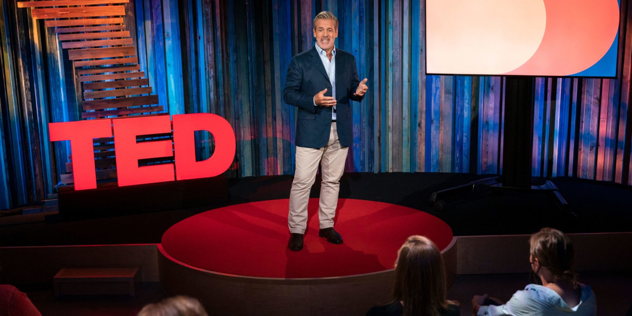 Warren Valdmanis on the TED Talk stage, speaking animatedly