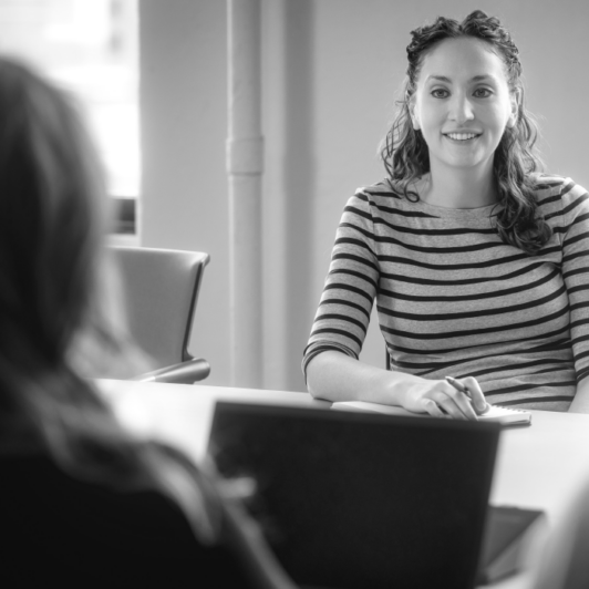 Two women collaborate in a conference room.