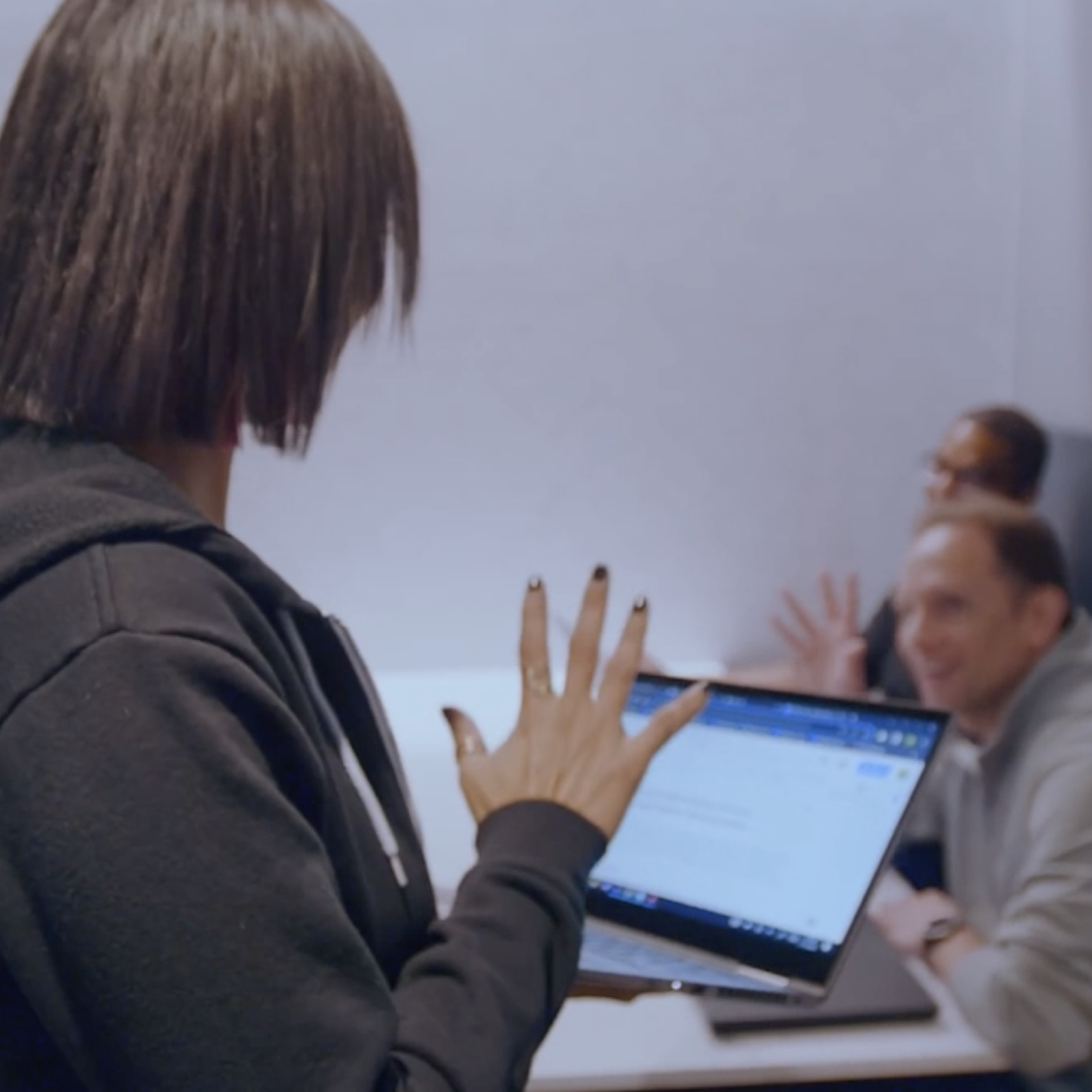 Two Sigma employees waving and smiling at each other.