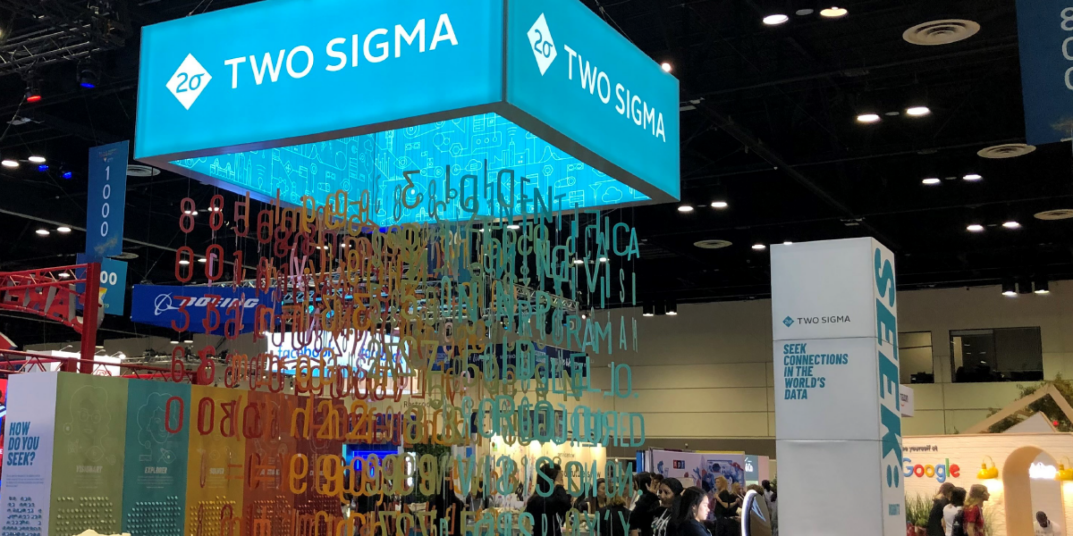 The Two Sigma booth at the Grace Hopper Celebration with a central installation which has hanging multicolored data with the illusion of floating.