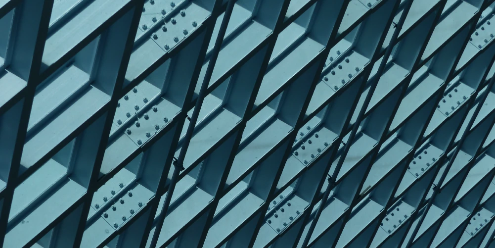 Close-up of repeating blue steel beams and riveted structural supports.