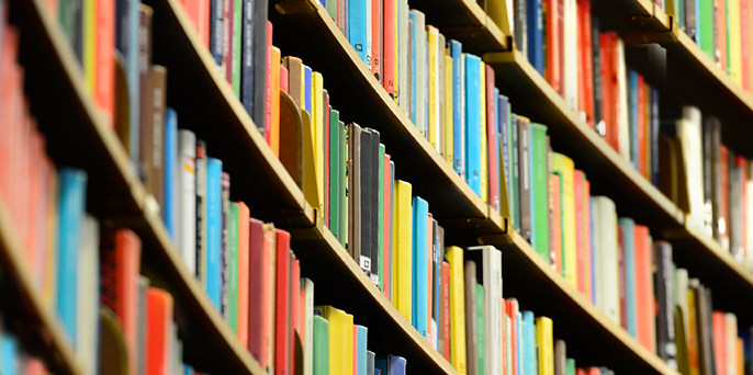 Curved library shelves filled with colorful book spines viewed at an angle.