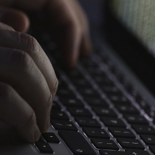 hands typing on a macbook