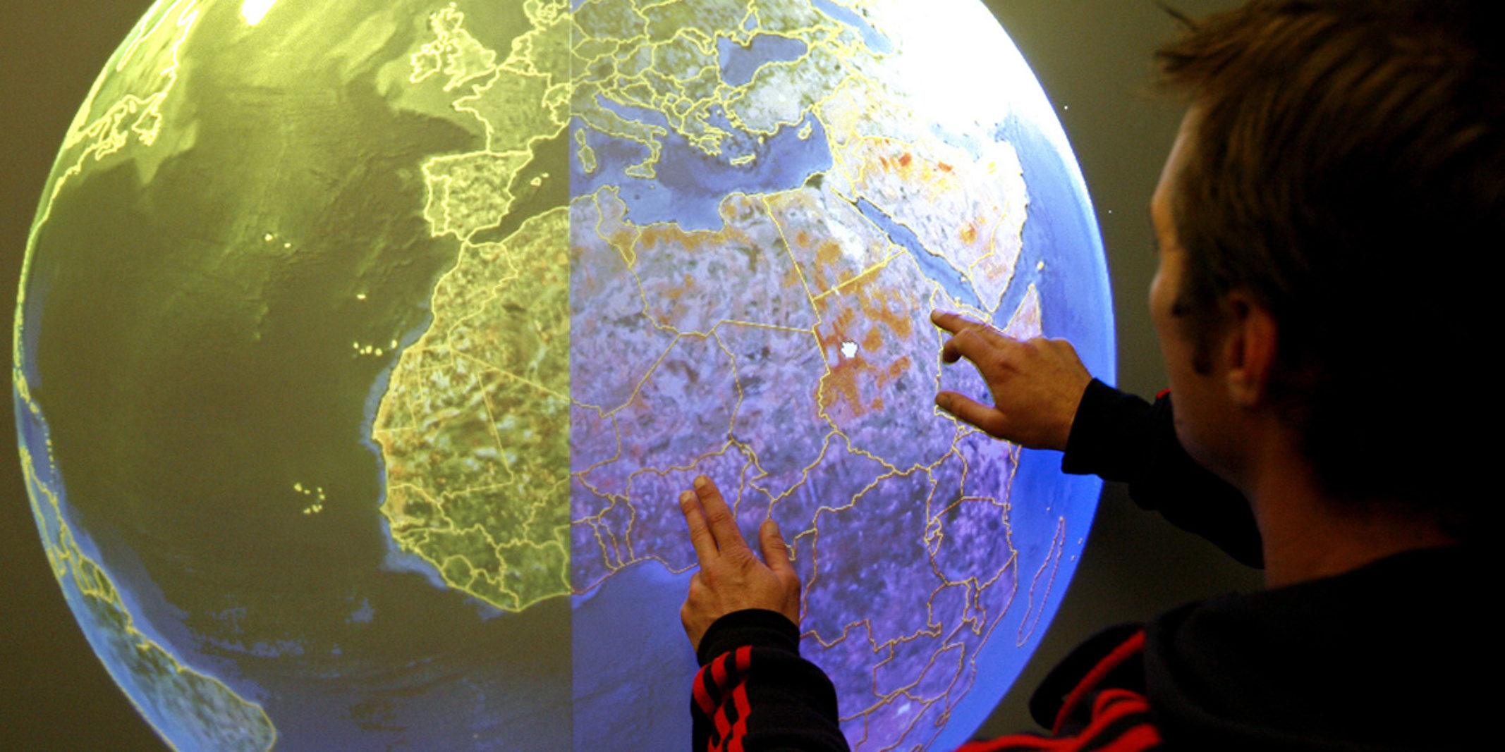 A man touching a digital model of the earth