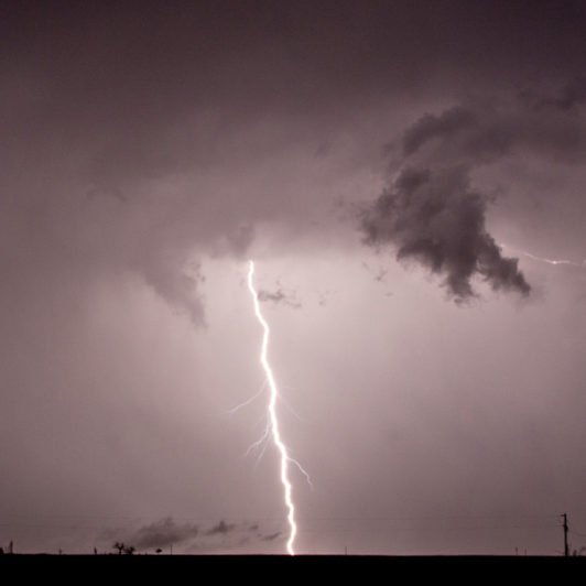 Thunder striking the ground while it is stormy and dark out